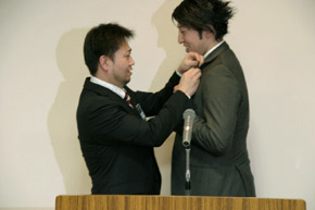 理事長よりバッジ授与された谷口君